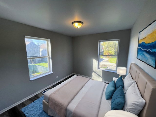 bedroom featuring multiple windows and dark hardwood / wood-style floors