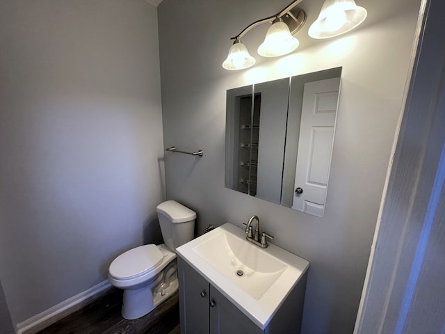 bathroom with hardwood / wood-style flooring, vanity, and toilet