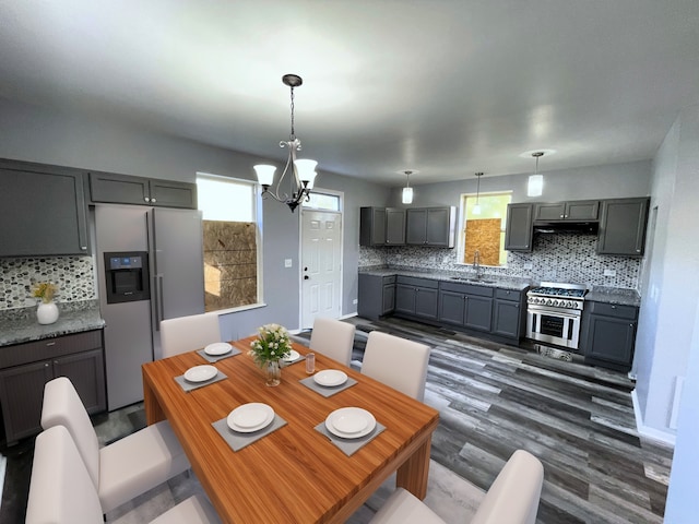 dining space featuring dark hardwood / wood-style flooring, sink, and a notable chandelier