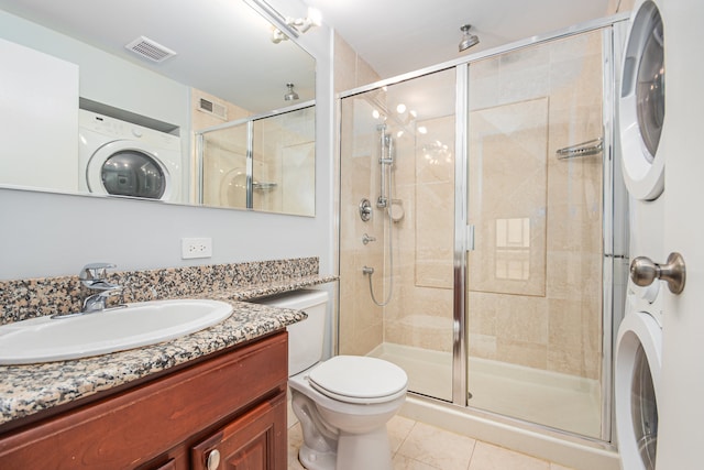 bathroom featuring washer / dryer, vanity, an enclosed shower, tile patterned floors, and toilet