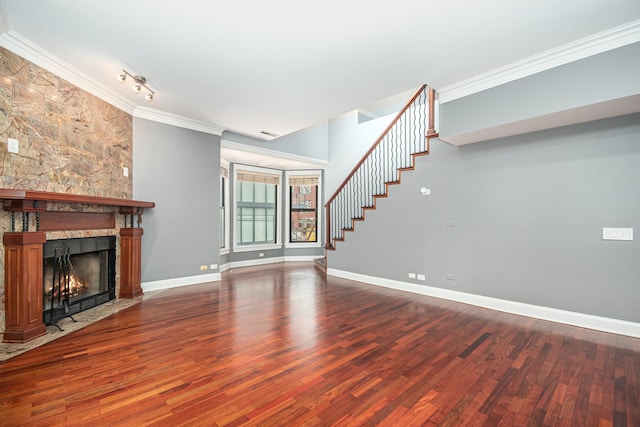 unfurnished living room with hardwood / wood-style floors, a large fireplace, and crown molding