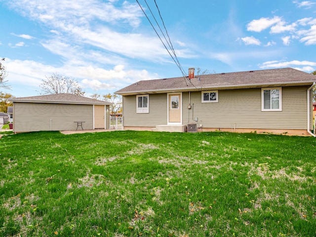 rear view of house featuring central AC and a lawn