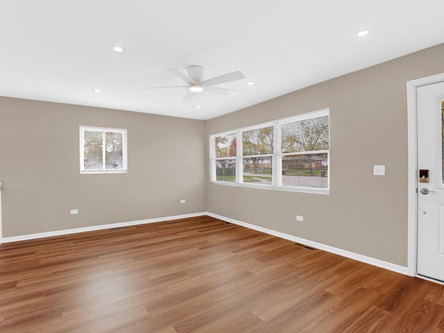 unfurnished room with ceiling fan, a wealth of natural light, and light wood-type flooring