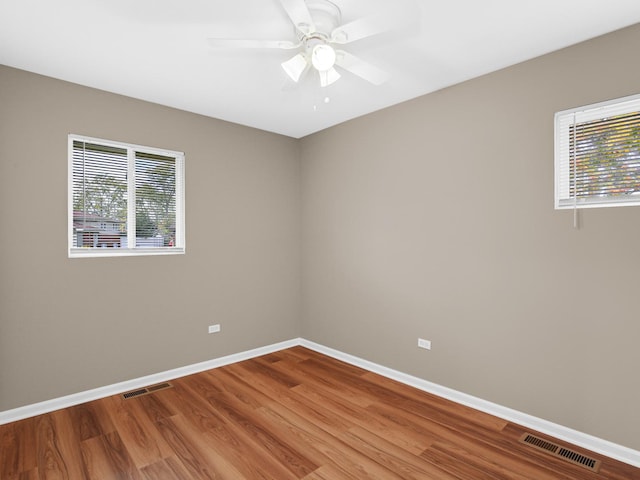 unfurnished room featuring ceiling fan, a healthy amount of sunlight, and wood-type flooring