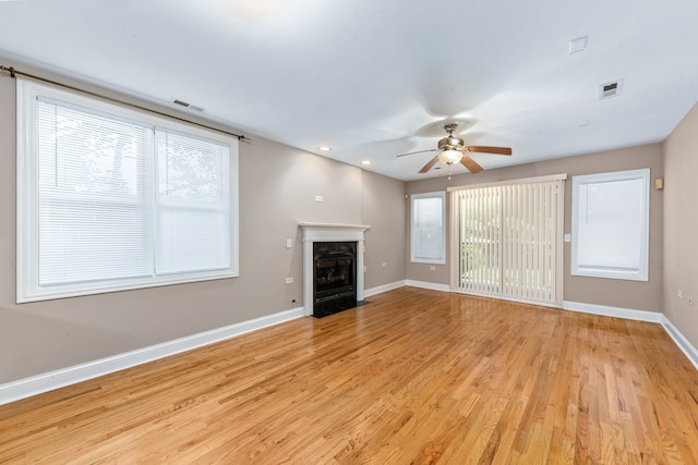 unfurnished living room with ceiling fan, a healthy amount of sunlight, and light hardwood / wood-style flooring