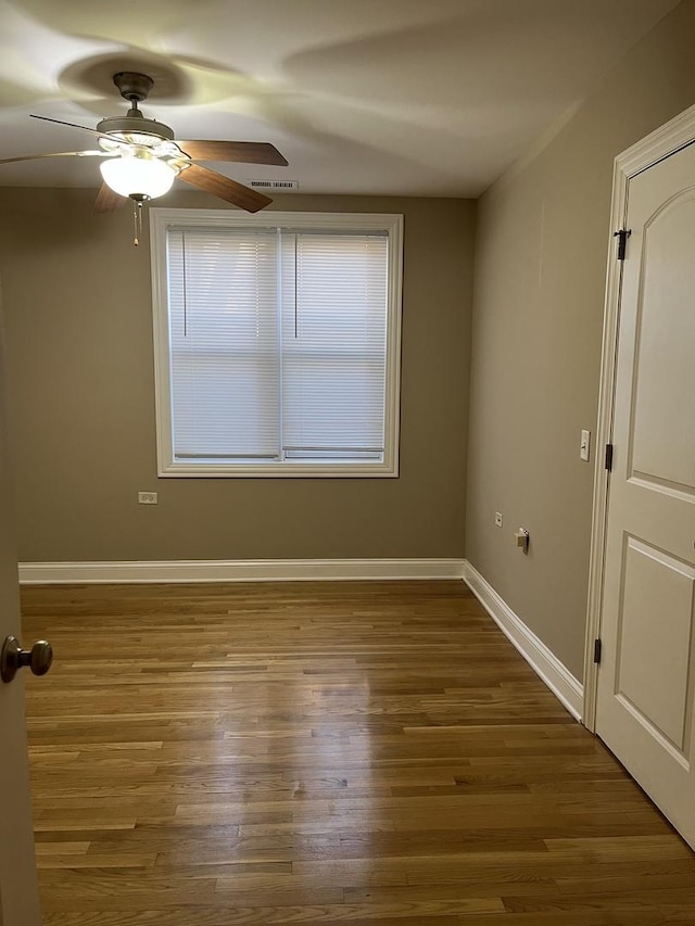 spare room featuring ceiling fan and dark wood-type flooring