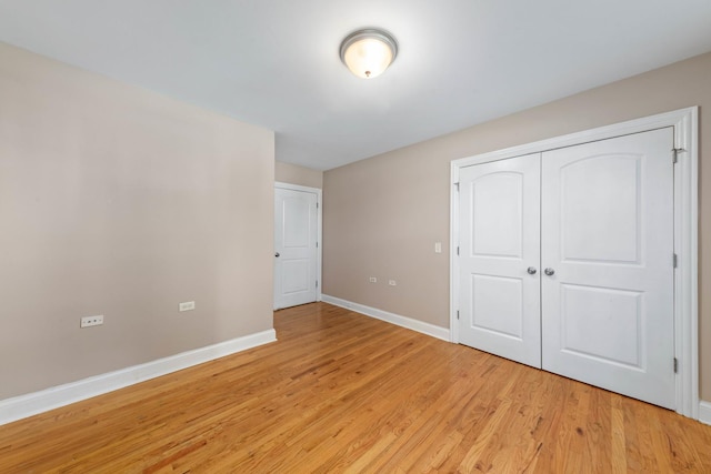 unfurnished bedroom featuring light hardwood / wood-style flooring and a closet