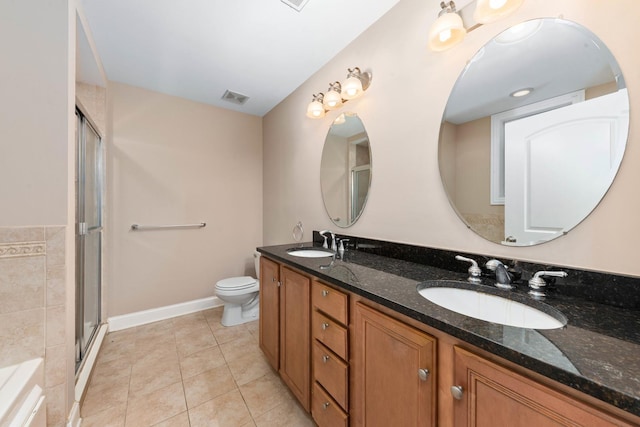 bathroom featuring tile patterned flooring, vanity, toilet, and walk in shower