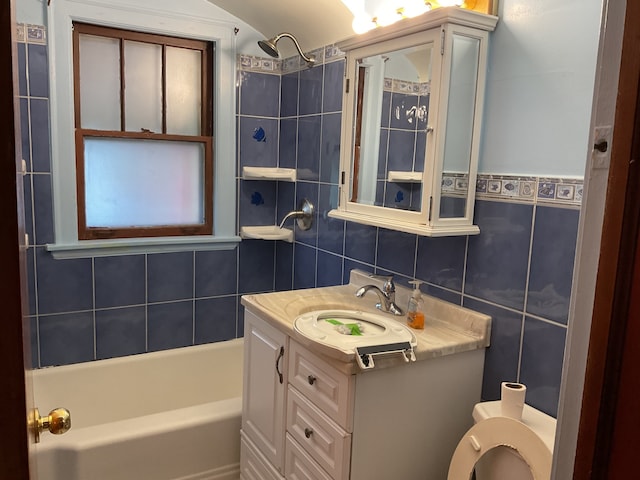 full bathroom featuring backsplash, vanity, toilet, tile walls, and tiled shower / bath combo