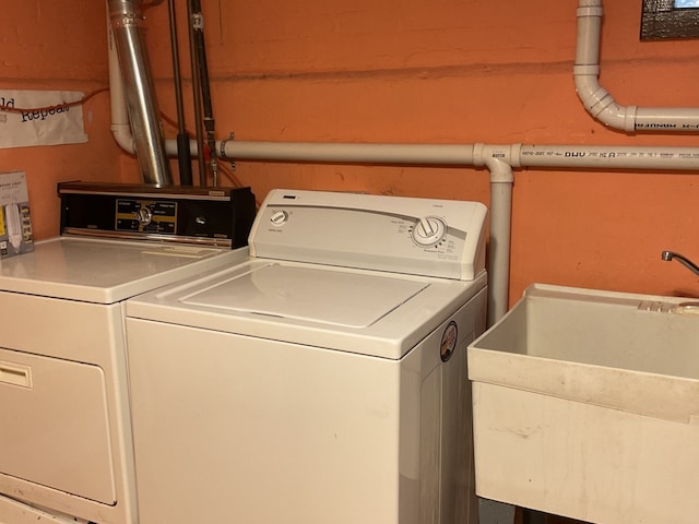 clothes washing area featuring washing machine and clothes dryer and sink