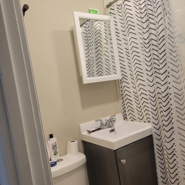 bathroom featuring walk in shower, vanity, and toilet