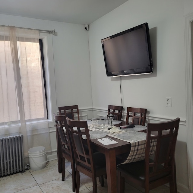 dining space featuring light tile patterned floors and radiator heating unit