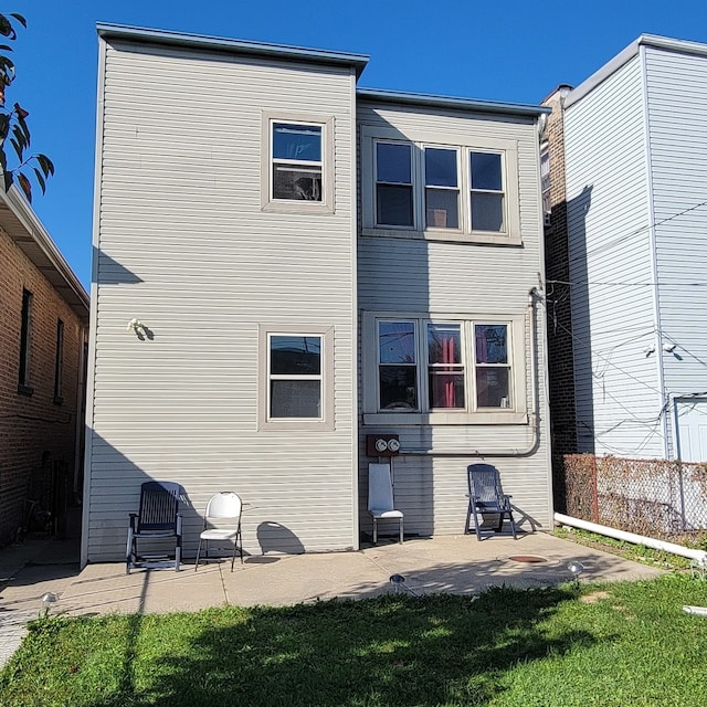 rear view of property with a lawn and a patio