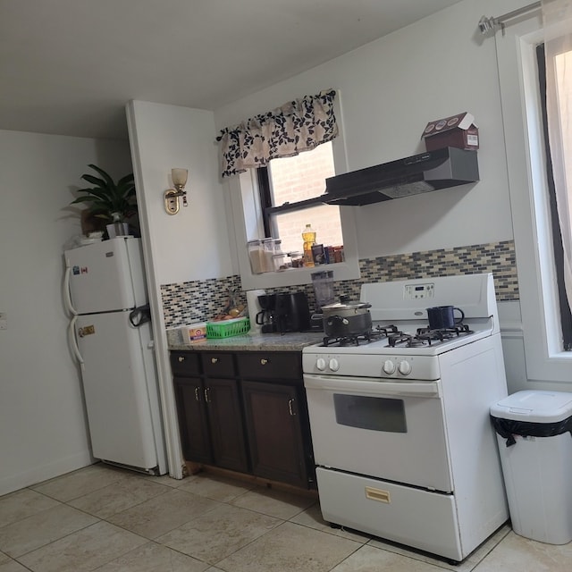 kitchen with dark brown cabinetry, white appliances, extractor fan, and decorative backsplash