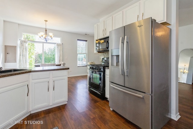 kitchen featuring white cabinets, appliances with stainless steel finishes, hanging light fixtures, and dark hardwood / wood-style flooring