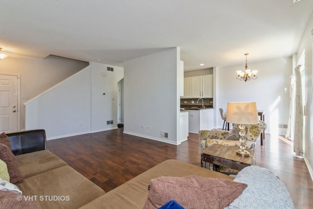 living room featuring a chandelier, sink, and dark hardwood / wood-style flooring