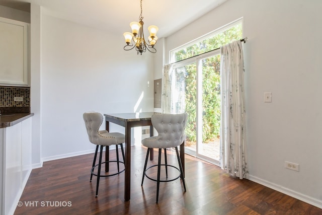 dining space with dark wood-type flooring and a notable chandelier