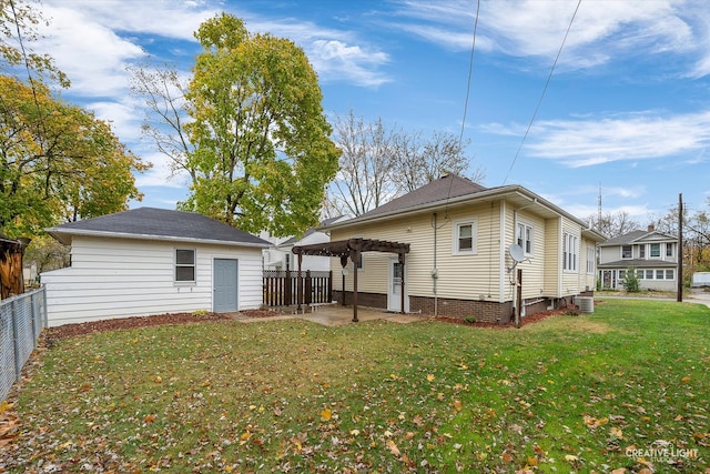 rear view of house with a patio area, a yard, and a pergola