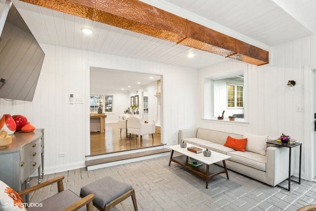 living room with plenty of natural light, light wood-type flooring, wooden walls, and wooden ceiling