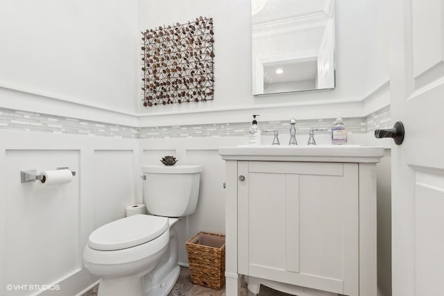 bathroom featuring vanity, toilet, and crown molding