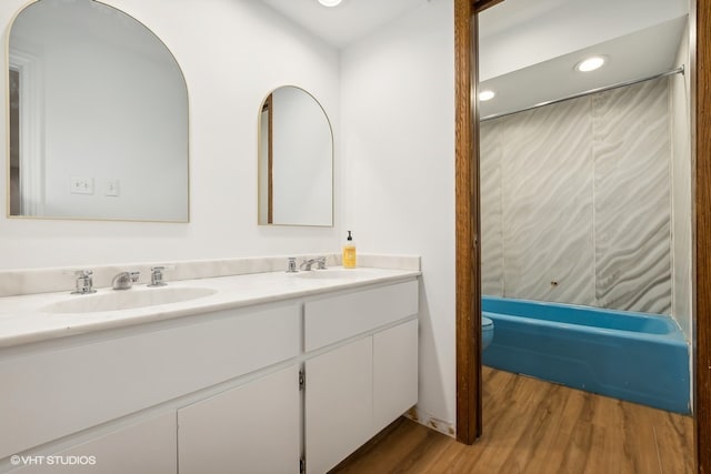 full bathroom with shower / tub combination, vanity, wood-type flooring, and toilet