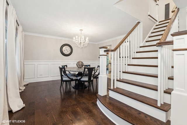 dining space with dark hardwood / wood-style floors, an inviting chandelier, and ornamental molding