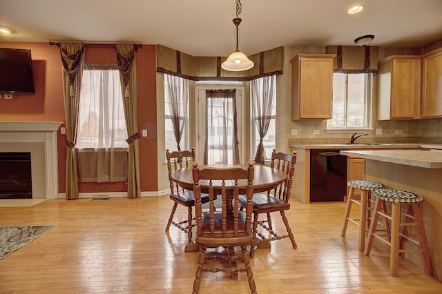 dining space with light hardwood / wood-style floors and sink