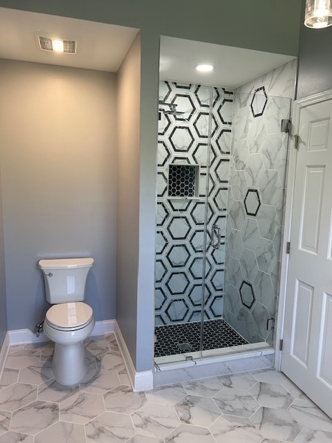 bathroom with walk in shower and toilet