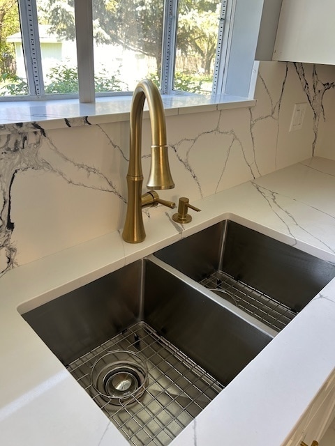 interior details featuring decorative backsplash and sink