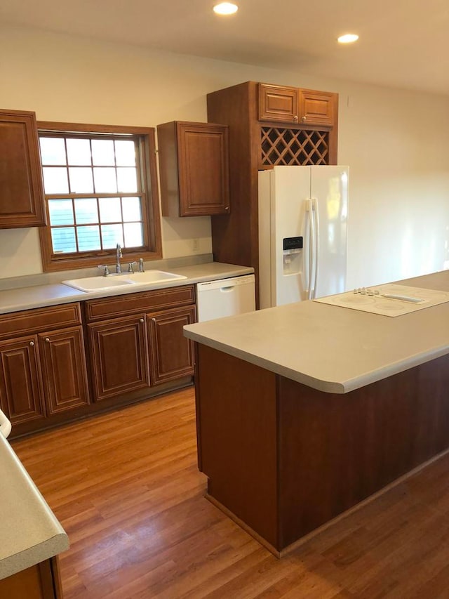 kitchen featuring light wood-type flooring, sink, and white appliances