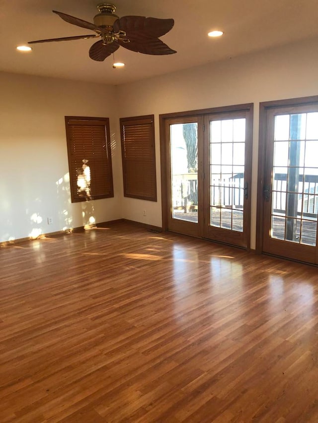 unfurnished room featuring french doors, dark hardwood / wood-style flooring, and ceiling fan