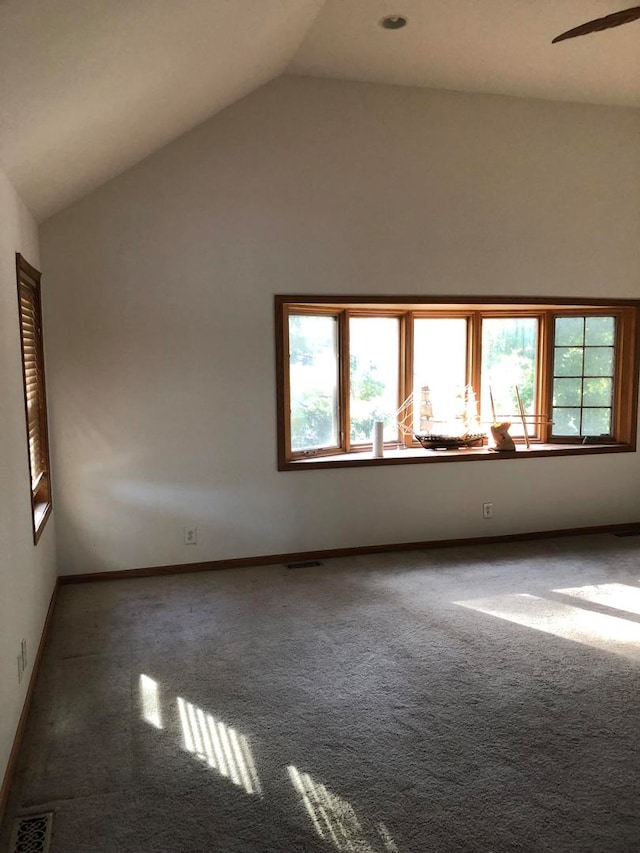 carpeted empty room featuring ceiling fan and high vaulted ceiling