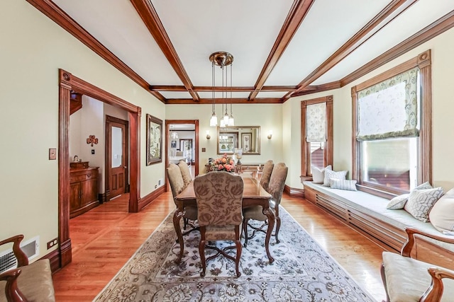 dining space featuring a notable chandelier, ornamental molding, and light hardwood / wood-style flooring