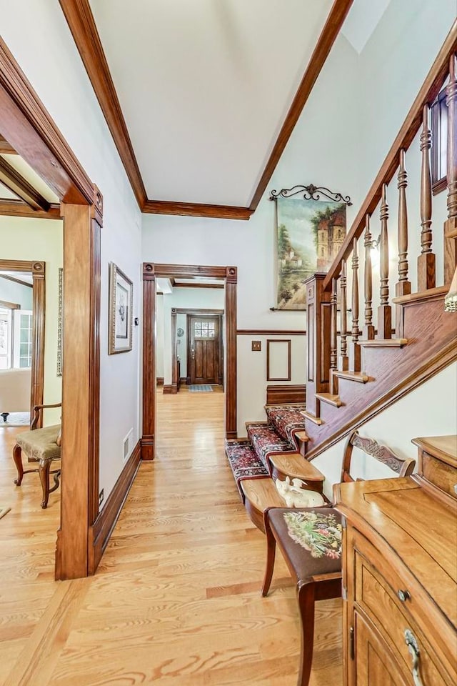 corridor featuring light hardwood / wood-style floors and crown molding