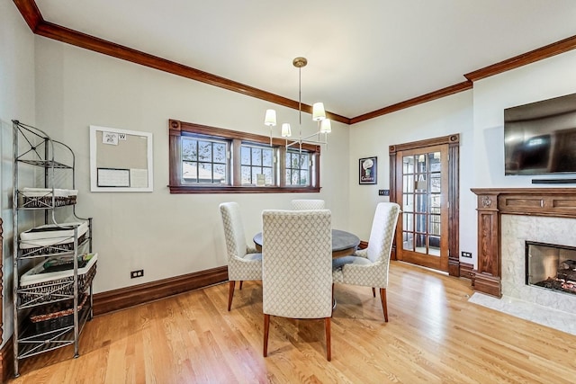 dining space with plenty of natural light, light hardwood / wood-style floors, and a high end fireplace