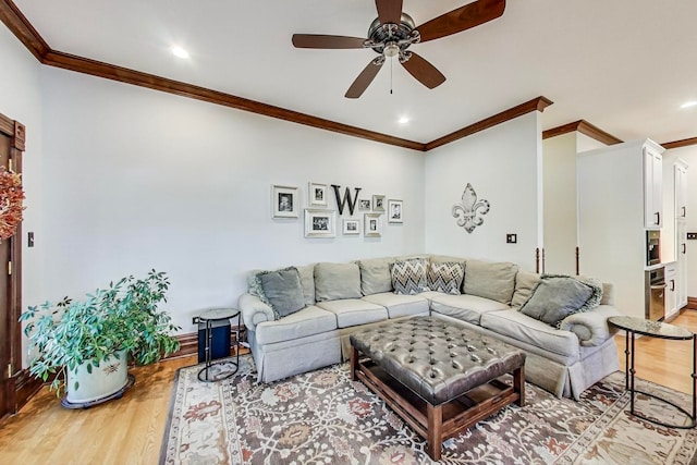 living room featuring crown molding, light hardwood / wood-style flooring, and ceiling fan