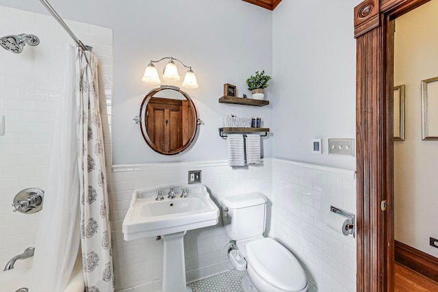 bathroom featuring shower / tub combo with curtain, hardwood / wood-style floors, tile walls, and toilet