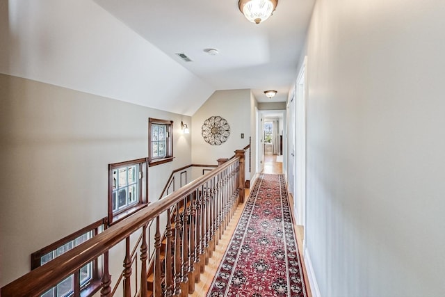 hallway featuring lofted ceiling and hardwood / wood-style flooring