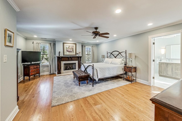 bedroom with connected bathroom, ceiling fan, sink, crown molding, and hardwood / wood-style floors