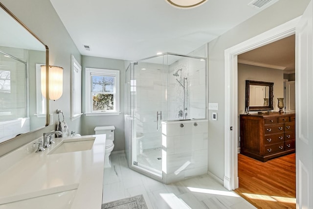 bathroom featuring vanity, wood-type flooring, crown molding, toilet, and a shower with shower door