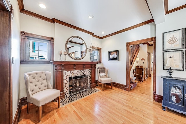 sitting room with light hardwood / wood-style floors, crown molding, and a fireplace