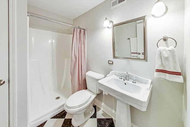 bathroom with toilet, walk in shower, and sink