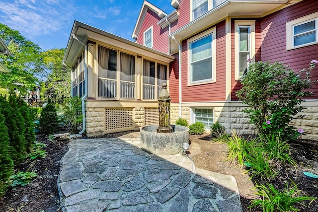 rear view of house featuring a patio and a sunroom