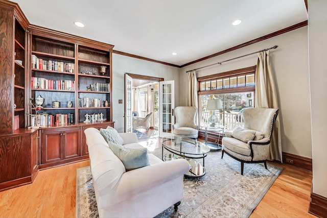 sitting room featuring french doors, ornamental molding, and light wood-type flooring