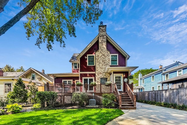 back of house featuring a lawn and a wooden deck