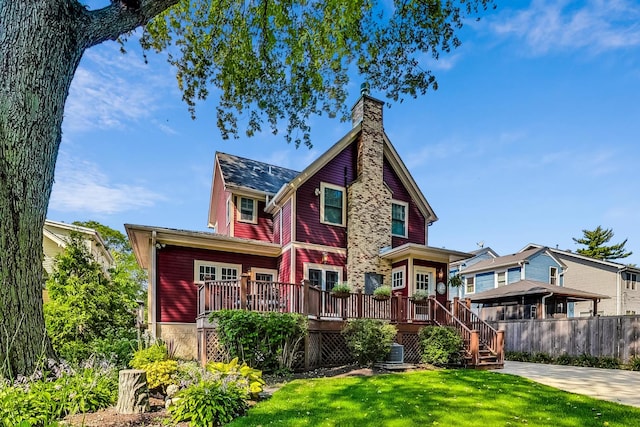 view of front of house featuring central air condition unit, a wooden deck, and a front yard