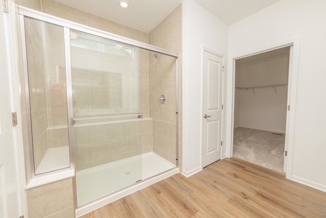 bathroom with hardwood / wood-style floors and a shower with door