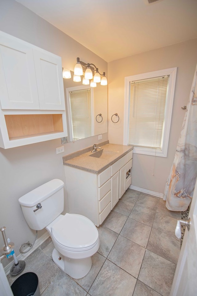 bathroom featuring vanity, tile patterned floors, and toilet