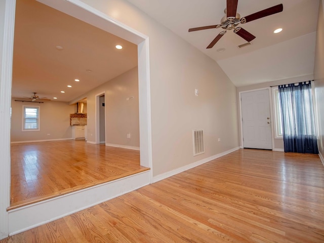 unfurnished living room with light hardwood / wood-style flooring, lofted ceiling, and ceiling fan