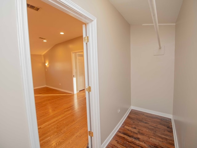 walk in closet featuring hardwood / wood-style flooring and vaulted ceiling